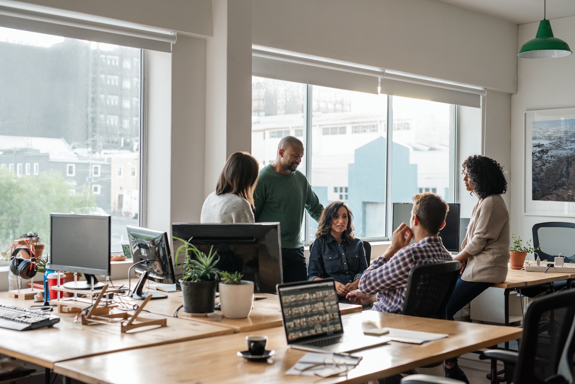 Smiling group of diverse designers meeting together in their office